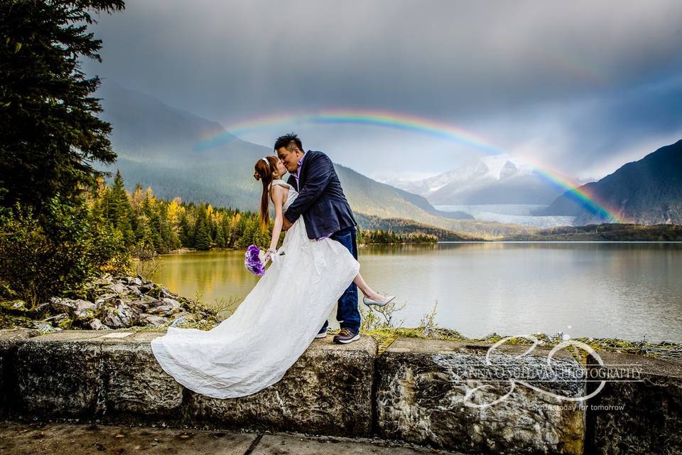 Couple kissing under rainbow