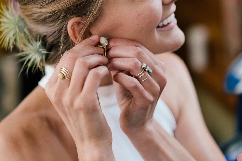 Bride putting on earrings