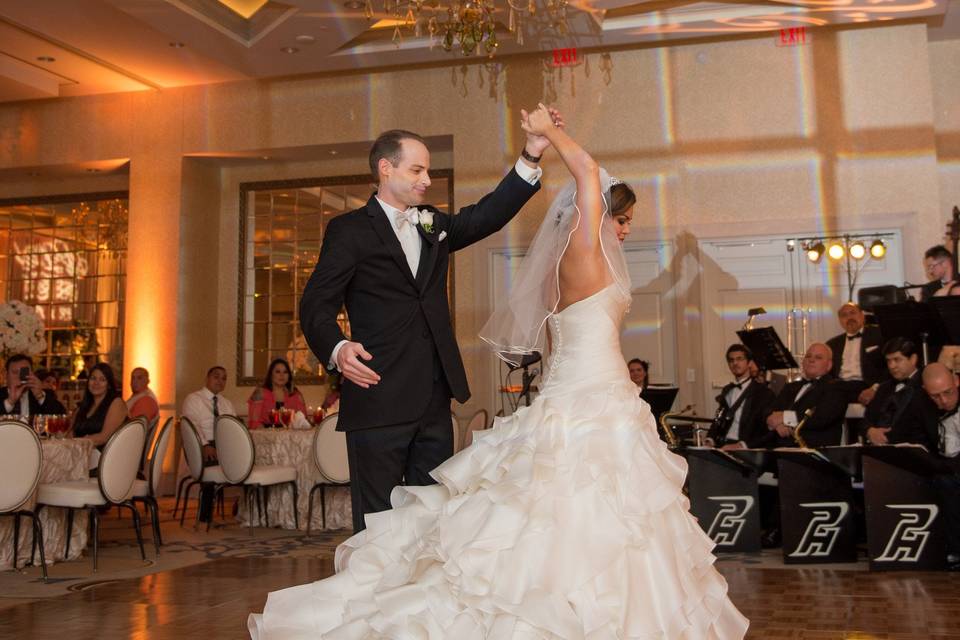 First dance in the Incanto Ballroom featuring elegantly ct out ceilings and tri-color crystal teardrop chandelieres