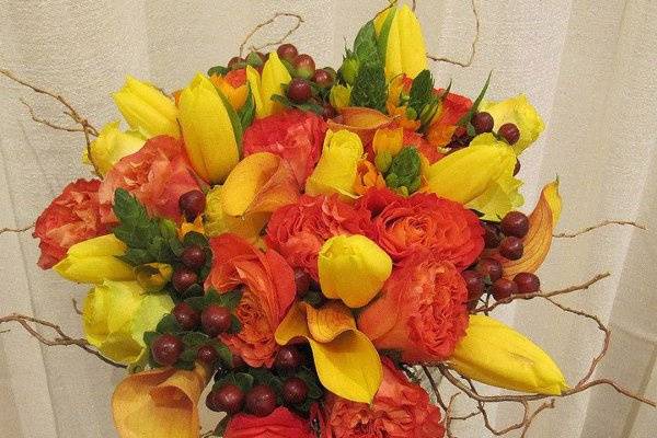 Fall colors with yellow tulips, orange roses, curly willow tips, burgandy hypericum berries and orange callas