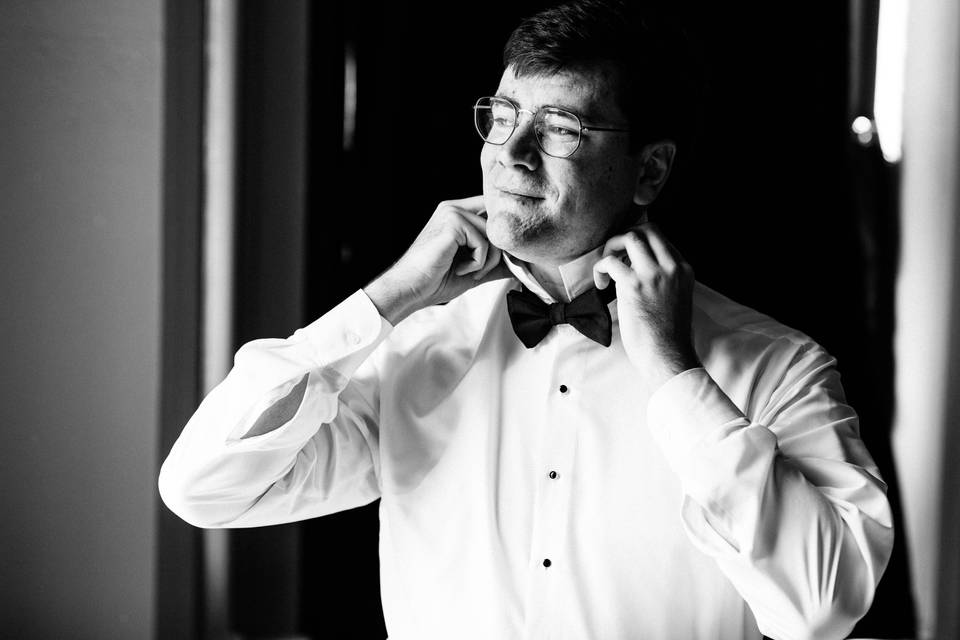 Groom adjusting bowtie