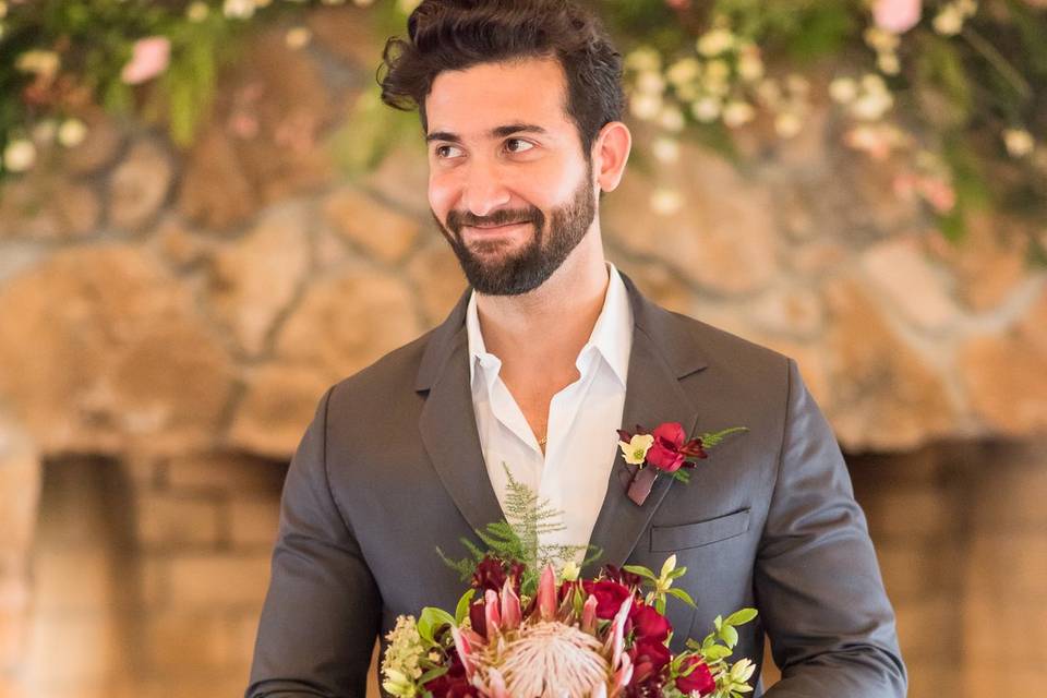 Groom holding bridal bouquet
