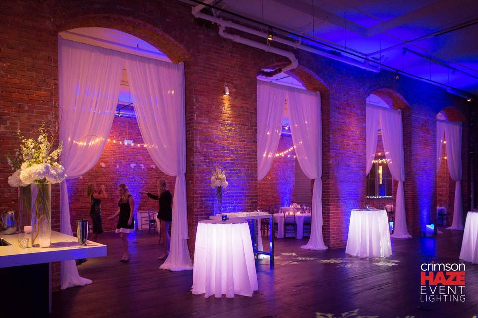 String lights, arch draping, and illuminated tables