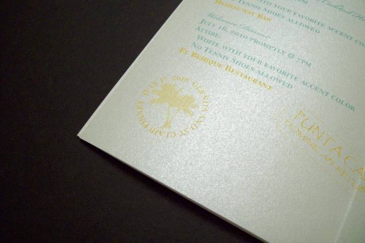 Passport invitation detail with custom stamps related to wedding.