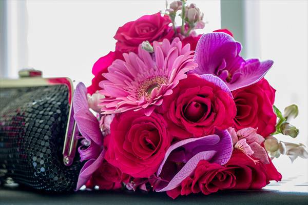 Gerber Daisies, purple vanda orchids and roses with a touch of snapdragons make this bouquet pop against any dress