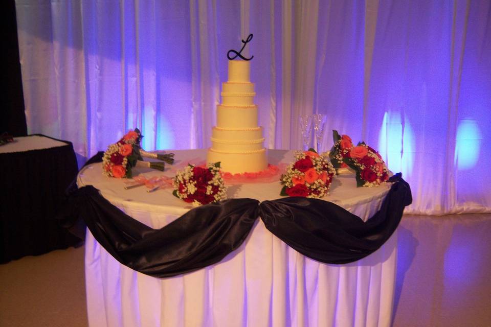 Cake table with navy sway and blue uplighting