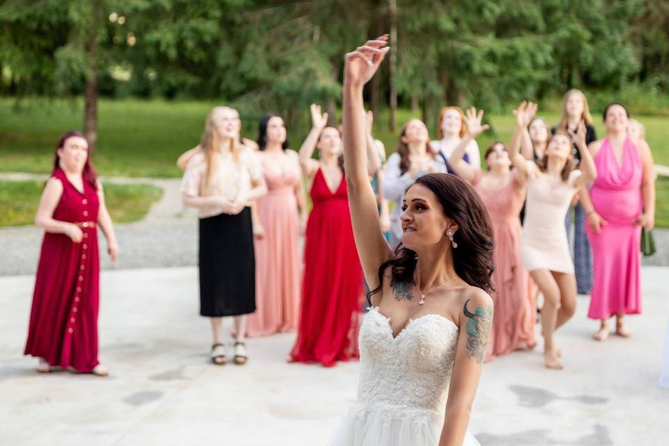 Bride tossing boquet on patio