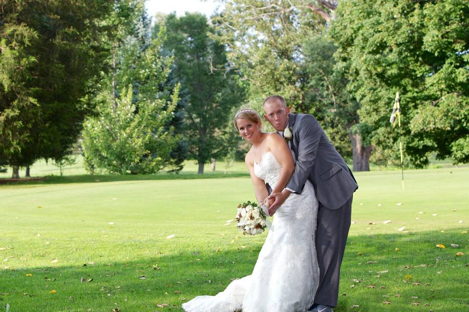 Newlyweds imitating a golf pose