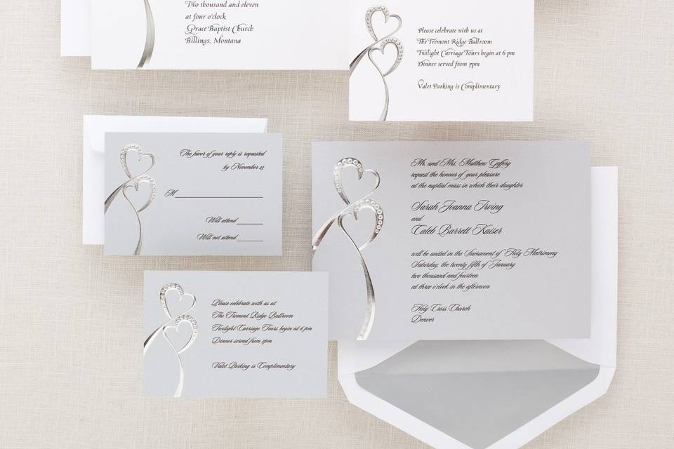Twin Hearts - This artful pairing of two silvery hearts creates a wedding invitation of remarkable impact and style. The shimmering paper stock gives a dazzling look. Available in pearl white or shimmering silver. Coordinates with our Twin Hearts wedding accessories. Order Your Free Sample Today!