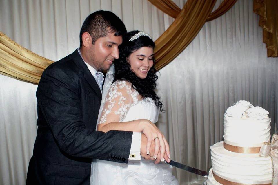 Buttercream cake being cut by the couple