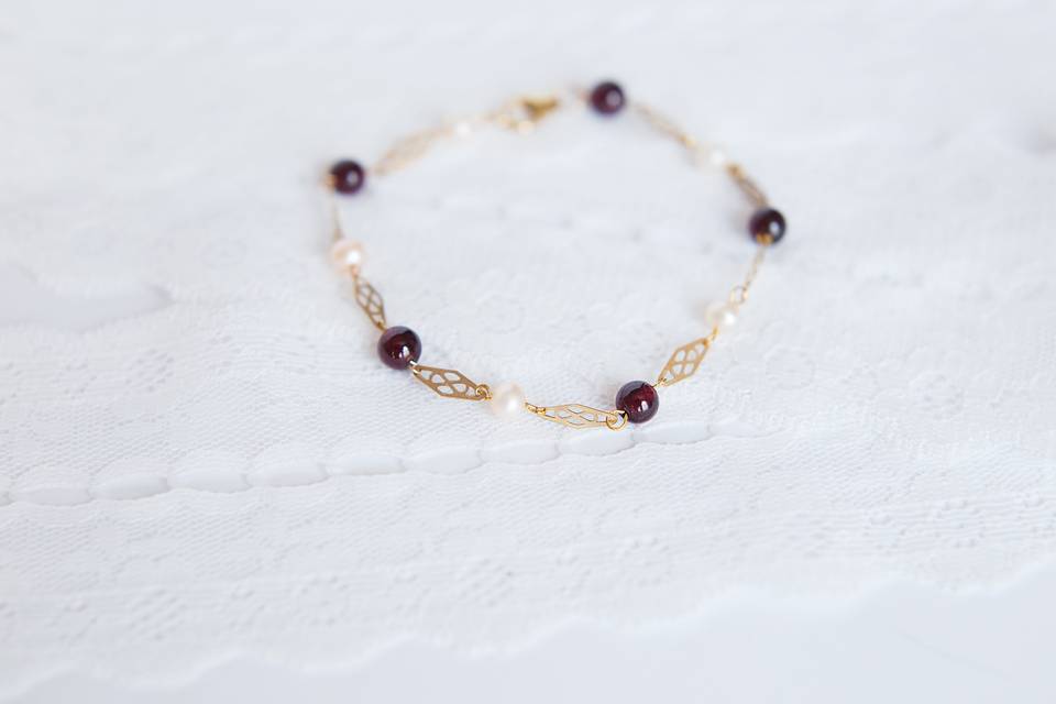 Handcrafted bridal bracelet of vintage maroon glass beads, peachy pink freshwater pearls, and gold plated filigree connectors. As seen in Style Unveiled, Fall 2014.Findings: Gold platedClosure: Lobster clasp Handcrafted to order at our studio in Baltimore, MD.
