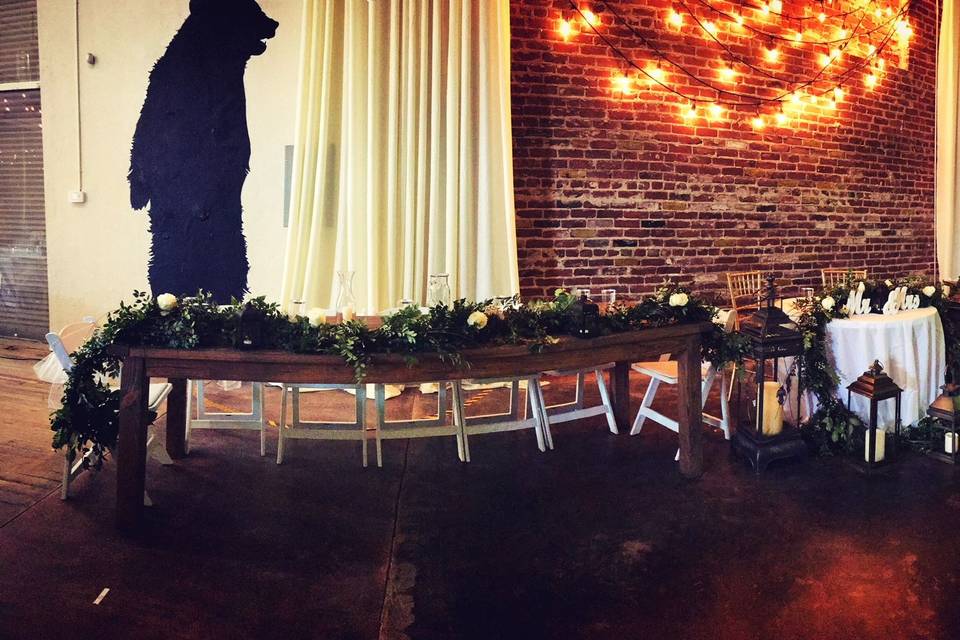 The couple with the bridesmaids and groomsmen table setup