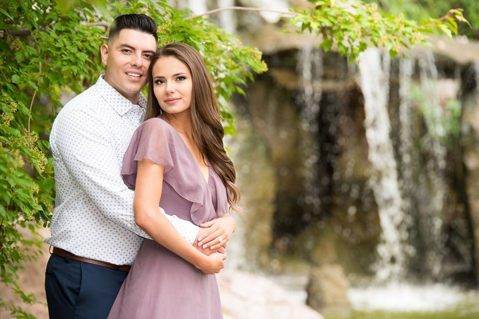 Couple posing beside waterfall