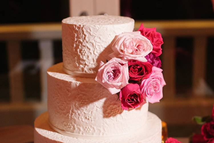Simple but elegant cake with a cluster of garden roses and petals.