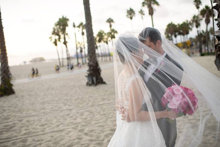 A romantic image of the newly wedded couple on the beach in Santa Monica, California.