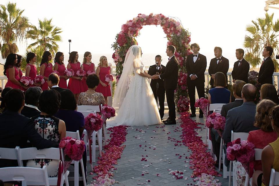 The wedding ceremony.  After a year of planning a beautiful wedding!  The garden arch, aisle flowers and petals down the aisle with the beach and palm trees in the background.