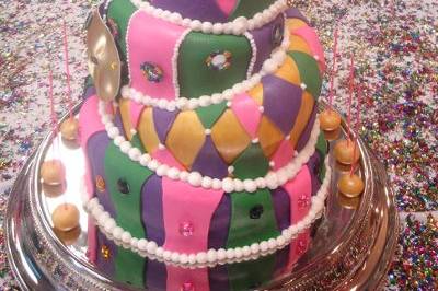 A fondant topsy turvy cake with a mardi gras theme.