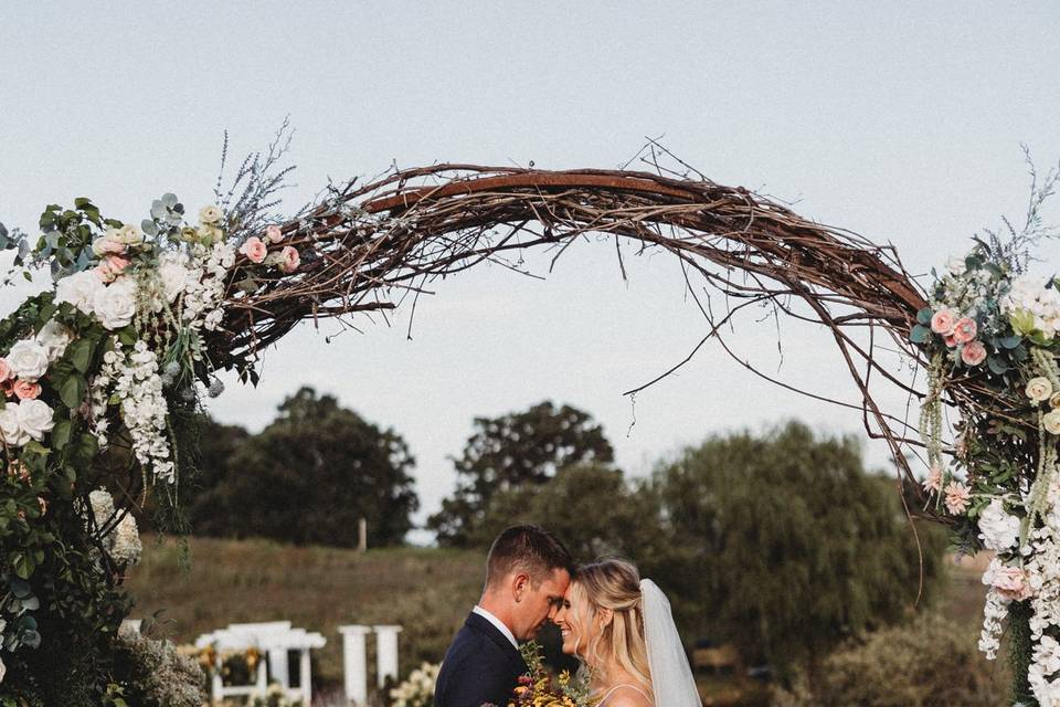 Couple Under Wedding Arch