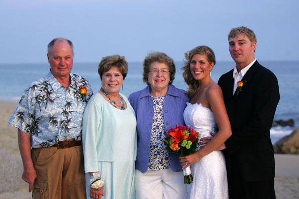Bride and groom with families on beach