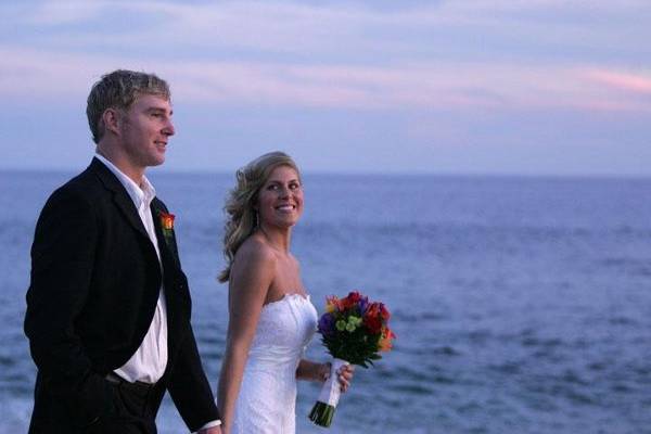 Bride and groom strolling on beach