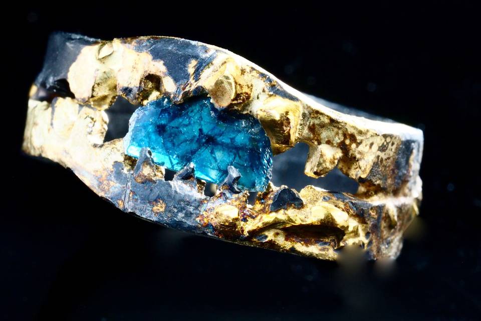 Rough blue diamond imbedded in oxidized silver and fused 18k gold band