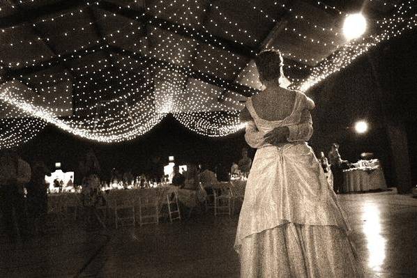 Reception where we transformed a gym to a great hall, complete with a ceiling of lights, walls draped in fabric and spot lights highlighting tables and the dance floor.