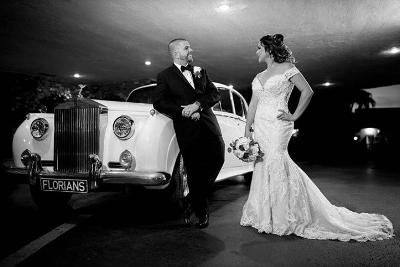 Couple by the wedding car