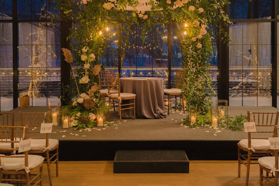 We hung Edison bulbs inside this chuppah at The Roundhouse in Beacon, NY. Florals by Dark & Diamond Floral Design. Photo by Matthew Ambrosini.