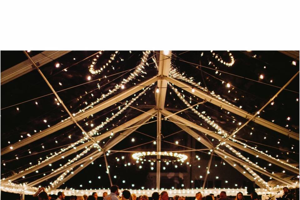 Bistro Lights & Metal Ring Chandelier in a clear-top tent. Photo by Kimberly Coccagnia.