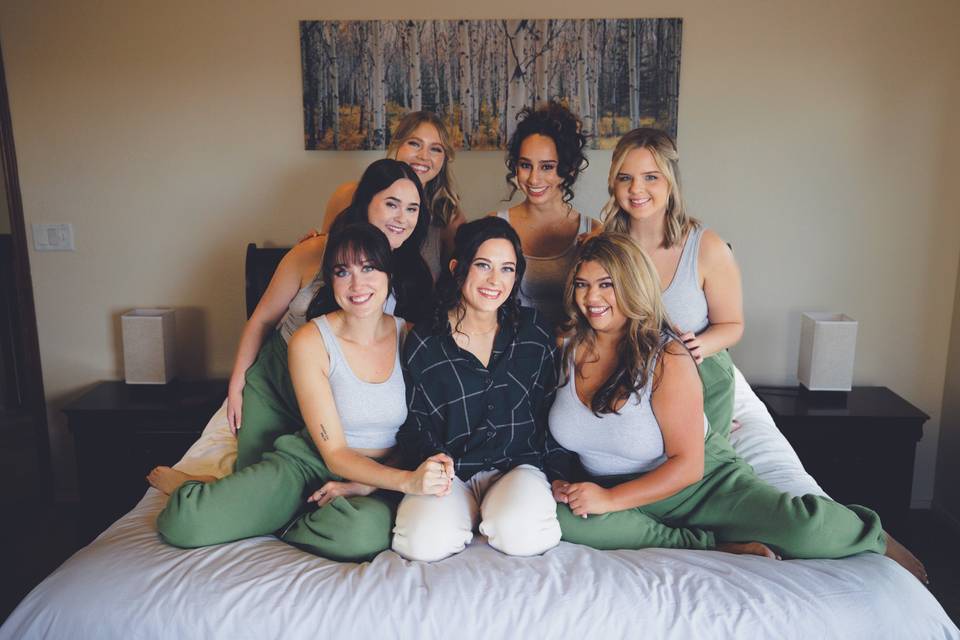 Bride with her ladies on a bed