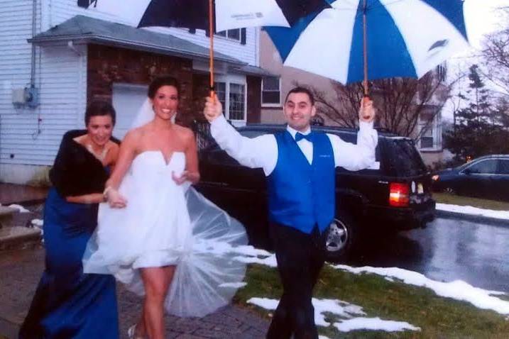 Bride being sheltered to the limo