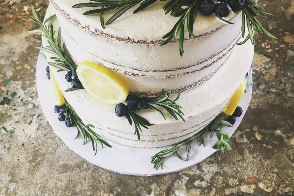 Lemon butter cake with fresh lemon curd and blueberry filling finished with Italian buttercream, lemons, rosemary, blueberries and succulents for a fresh yet earthy look.