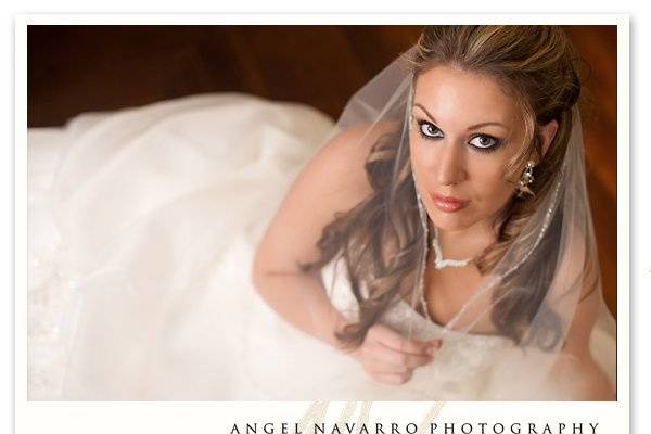 Bride lying on a wooden floor in her wedding dress for a bridal portrait.