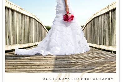 A beautiful outdoor bridal portrait of a bride in her wedding gown on a wooden bridge.