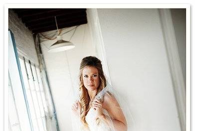 A very trendy photo of a bride in her wedding dress poised in a hallway.