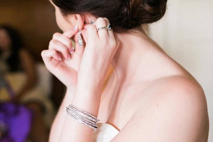 Bride putting on her earrings