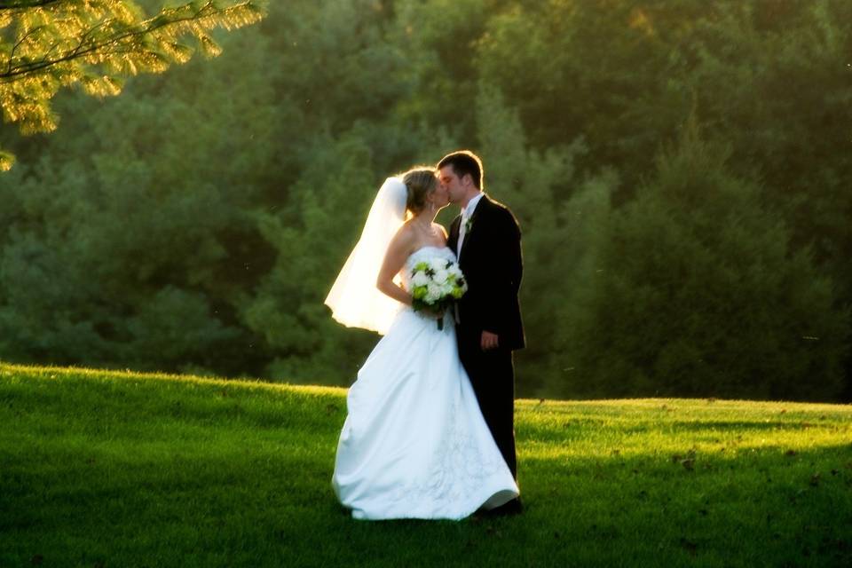 Bride and groom kissing on the field