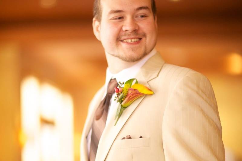 The happy Groom looking dapper in an ivory beige suit jacket