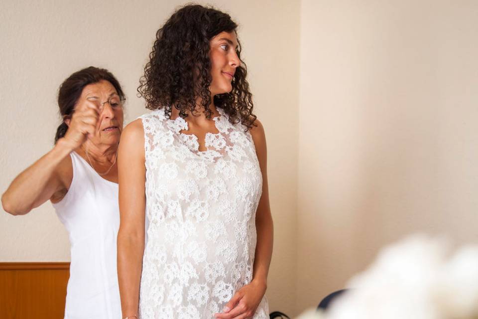 Mother of the bride doing final touches to the brides dress in Destination wedding in Frankfurt, Germany