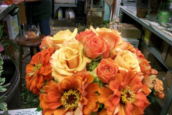 Bouquet in the making - so vibrant!  2 shades of orange roses, with summery zinnias.