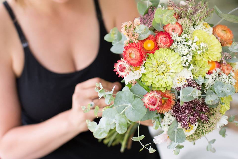 Maya working on a bridal bouquet on-site in july - 100% hillen homestead flowers. Photo by jamie kovach