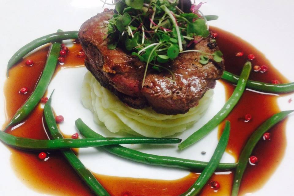 Pan roasted filet mignon served with yukon gold whipped potatoes, haricot verts and a pink peppercorn demi glaze.