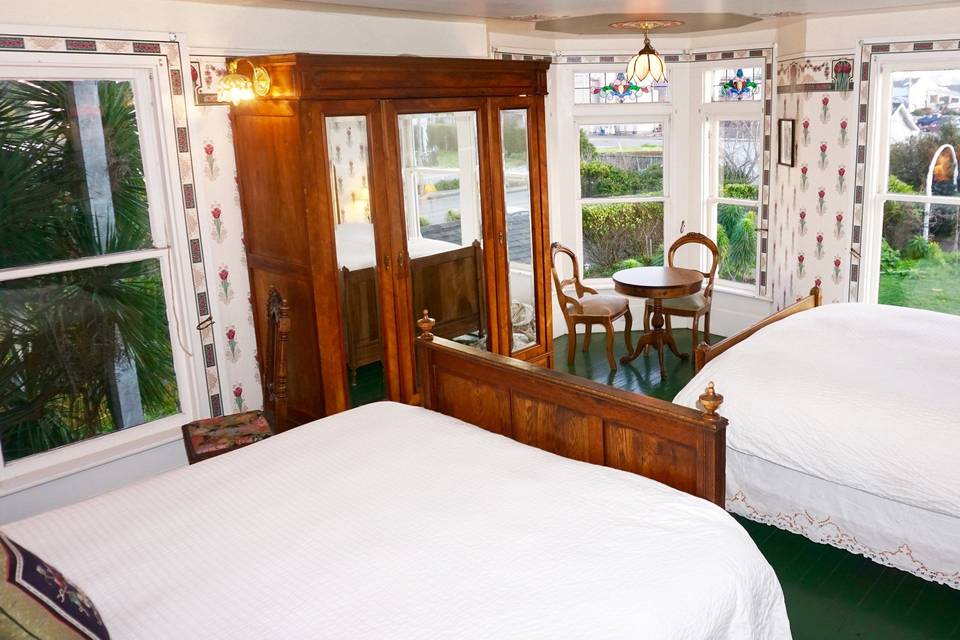 Tulip room with 1 king, 1 queen bed, and 6 windows facing east and south (usually the room selected as complimentary bridal chamber), overlooks front lawn and garden area for wedding ceremony