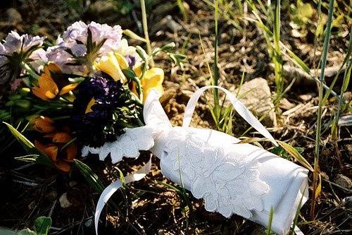 The bride's bouquet was a small bouquet made of matsomotos, orange dubium, lavender scabiosa and more.  The flowers were tubed and placed in a custom designed bouquet holder made by the flower shop from the bride's wedding gown scraps.  It was tied with white satin and held an applique like her gown.