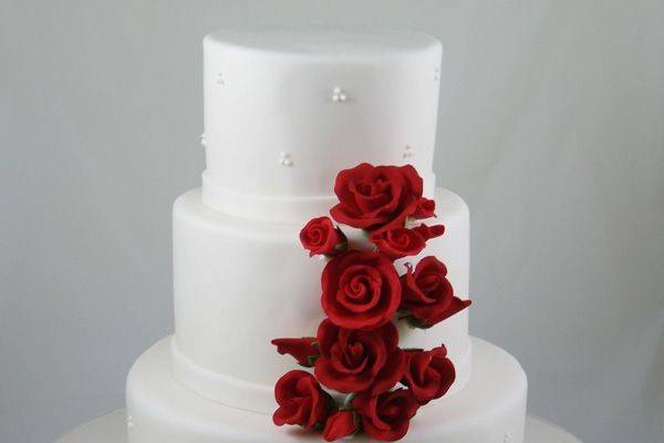 All white wedding cake with red roses