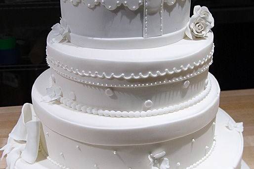 All white wedding cake with bow on top