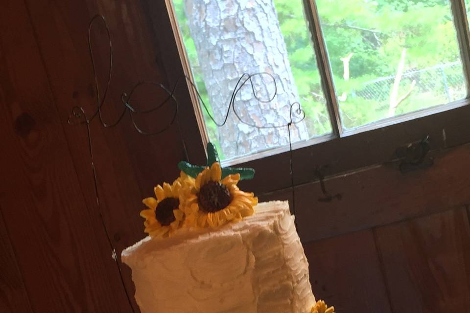 White wedding cake with sunflowers