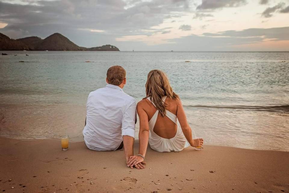 Bride and groom sitting at the beach