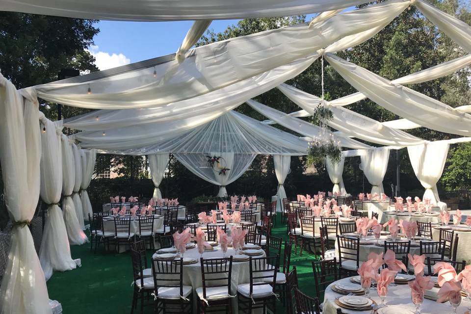 Outdoor reception with white drapes overhead