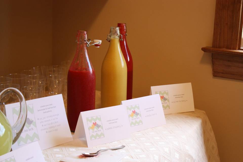 Beverage bar including the fixins for raspberry, strawberry or peach mimosas, iced teas or lemonades.